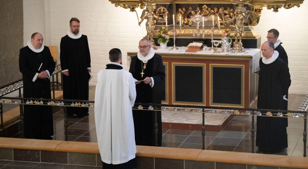 Lars Östman står foran Henning Toft Bro ved alteret