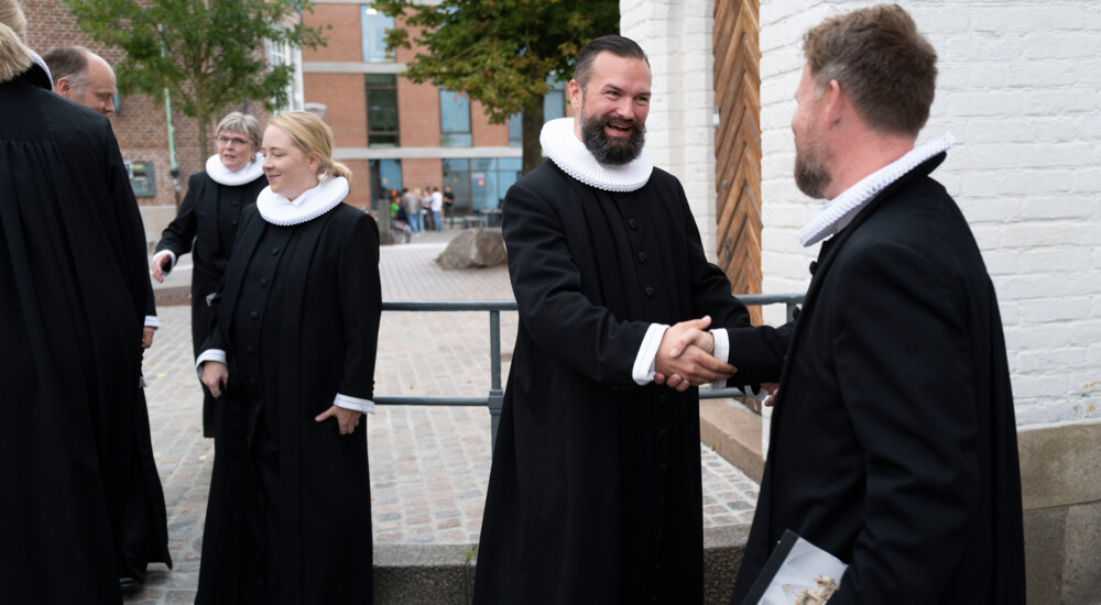 Lars Östman giver hånd til præst