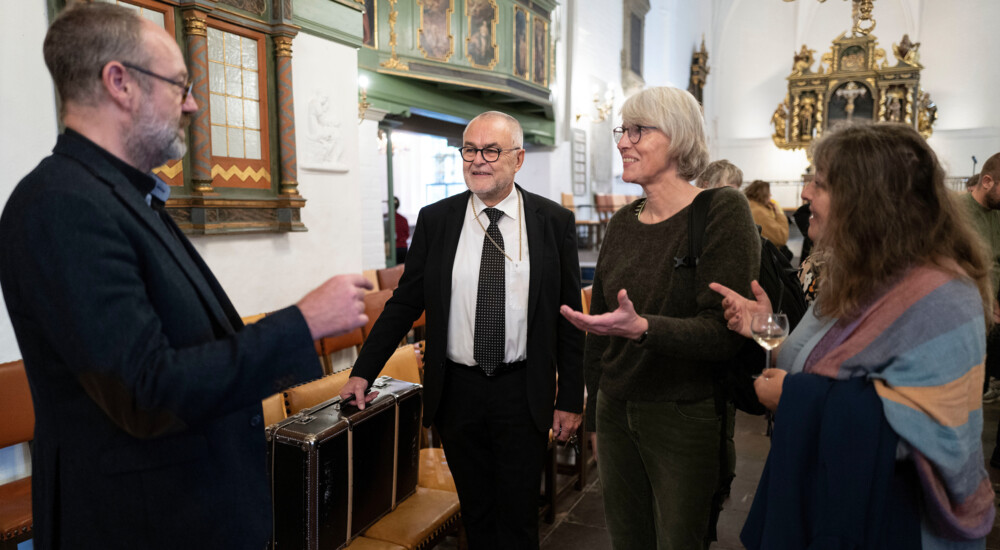 Biskop snakker med to kvinder og en mand